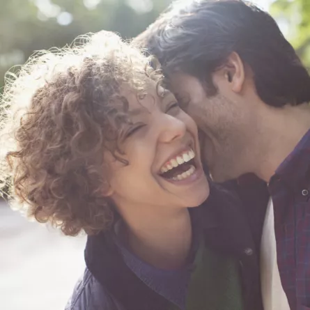 Close up laughing couple hugging