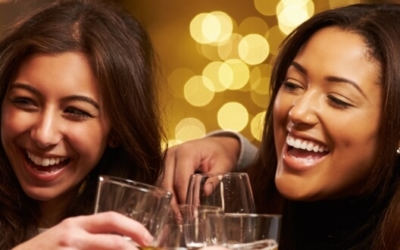 Young women laughing and drinking alcohol