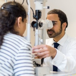 Male optometrist examines a girl's eyes