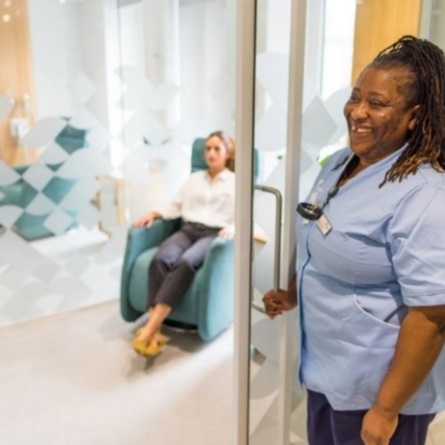 Woman sits on chair in Optegra treatment room