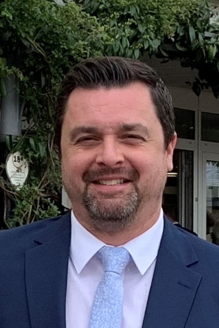 Headshot of a dark haired man