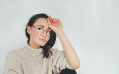 Woman in glasses clears hair from her eyes